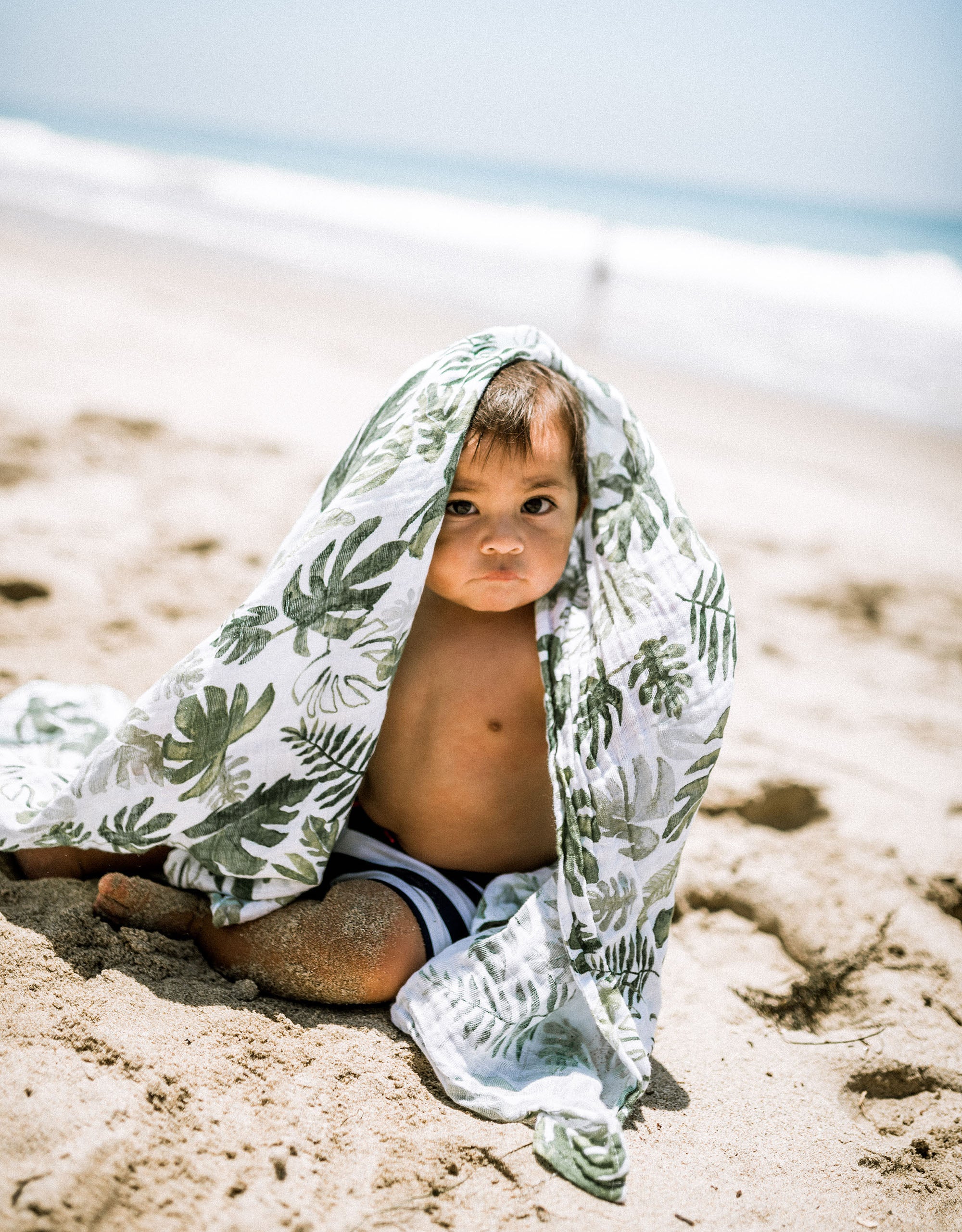 little unicorn cotton muslin swaddle in tropical leaf